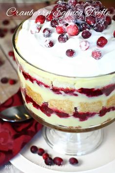 a cake with white frosting and cranberries on top sitting on a plate