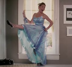 a woman in a blue dress is dancing