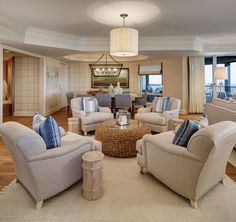 a living room filled with furniture and a chandelier hanging over the top of it