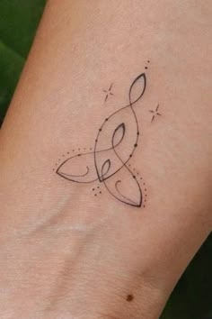 a woman's wrist with a musical note tattoo on the left side of her arm