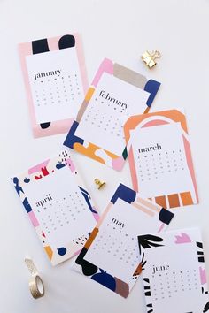 three calendars with different designs on them next to some gold rings and other items