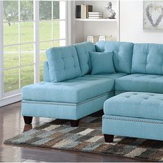 a living room with a blue sectional couch and ottoman