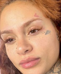 a close up of a person with tattoos on her face