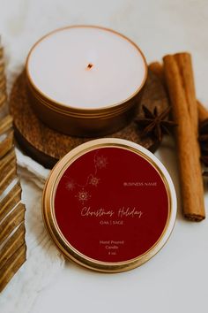 a candle and some cinnamon sticks are on a table with other holiday items around it