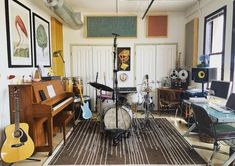 a room filled with lots of musical instruments and music equipment on top of a rug