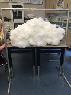 a woman standing next to a table covered in cotton balls