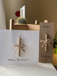 two greeting cards tied with twine on top of a table