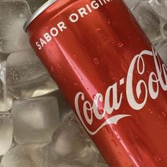 a can of coca cola sitting on top of ice cubes