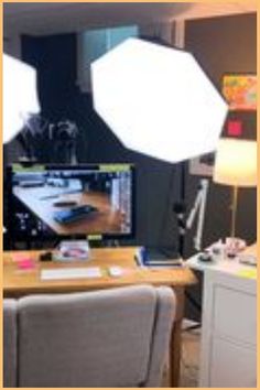 a desk with two lamps on it and a television in the backround behind it