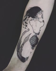 a black and white photo of a woman's arm with a fish tattoo on it