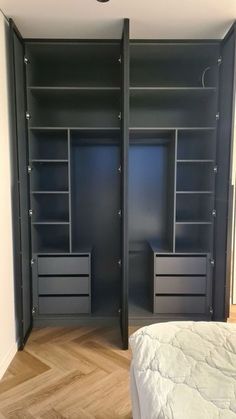 an empty bedroom with black shelves and drawers