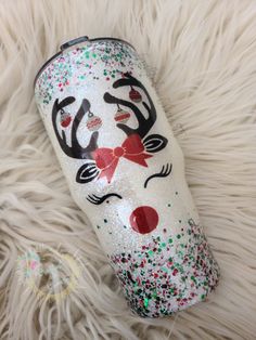 a christmas themed tumbler laying on top of a fur rug