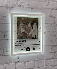 a white brick wall with a light up photo frame on it