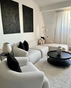 a living room with white furniture and black accents