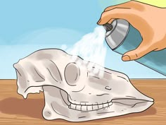 someone spray painting a skull with white paint