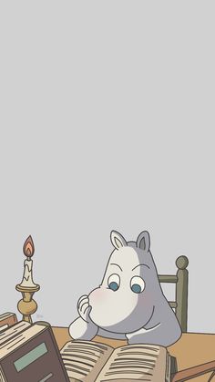 an animal sitting at a table reading a book with a candle in front of it