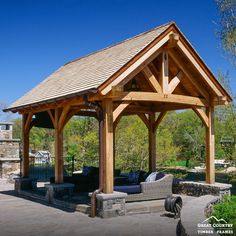 a covered patio with couches and an outdoor fireplace