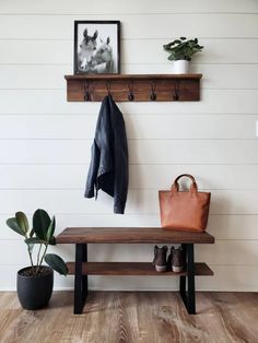 a wooden bench sitting next to a potted plant on top of a hard wood floor