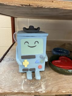 a toy robot sitting on top of a wooden shelf