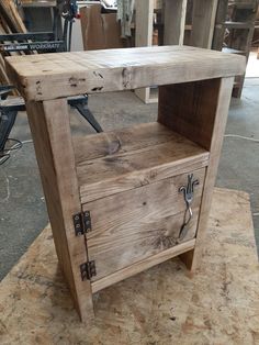 a wooden table with a drawer on top of it in a room filled with woodworking tools