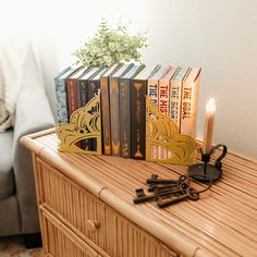 a wooden table topped with lots of books next to a vase filled with flowers and keys