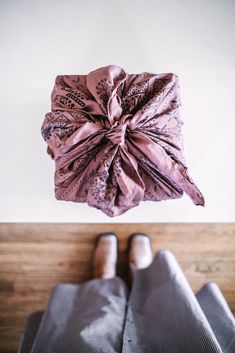 someone's feet on top of a bed wearing slippers and a bow tie