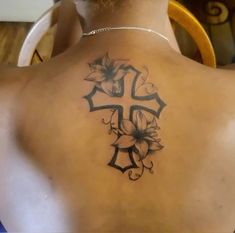 a man with a cross and flowers tattoo on his back