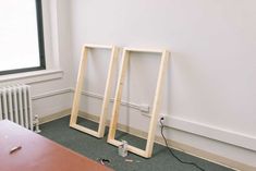 an empty room with two wooden frames on the floor and a radiator next to it