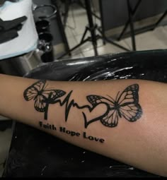 a person with a tattoo on their arm that says faith hope love and two butterflies