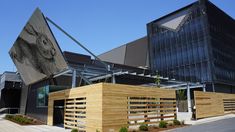 a modern building with wooden slats on the outside and an artistic mural on the front