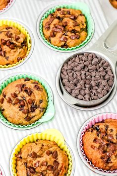 chocolate chip muffins in paper cups on top of a table with other muffins