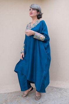 Blue kaftan with resham, zardozi applique embroidered V neck and sleeve cuffs. Paired with printed straight fit pant.
Components: 2
Pattern: Applique Embroidered
Type Of Work: Resham and Zardozi Work
Neckline: V Neck
Sleeve Type: Batwing Sleeves
Fabric: Pure Silk
Color: Blue
Other Details: 
Cut work hem details
Asymmetric hem on kaftan
Note: The outfit worn by the other model on the left is not for sale
Occasion: Mehendi and Haldi,Sangeet - Aza Fashions Blue Palazzo Set With Embroidered Border For Navratri, Blue Embroidered Palazzo Set With Traditional Drape, Blue Palazzo Set With Embroidered Border, Festive Blue Kaftan With Dupatta, Blue Kaftan With Zari Work For Diwali, Blue Zari Work Kaftan For Diwali, Blue Embroidered Straight Kurta Kaftan, Anarkali Kaftan With Embroidered Border For Eid, Blue Bollywood Kaftan With Resham Embroidery