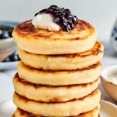 a stack of pancakes topped with blueberries and whipped cream