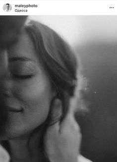 black and white photograph of a man kissing a woman's face with her eyes closed