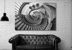 a black and white photo of a couch in front of a wall with a spiral design on it