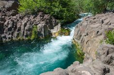 a river running between some rocks and trees