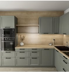 a kitchen with gray cabinets and wooden counter tops