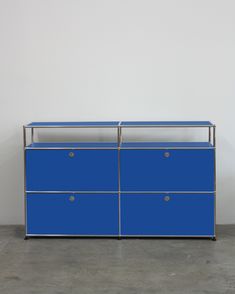 a blue dresser with two drawers on one side and a white wall in the background