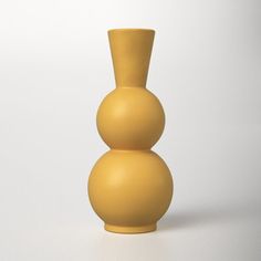 a yellow vase sitting on top of a white table