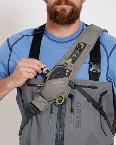 a man with a beard is holding an object in his back pocket and looking at the camera