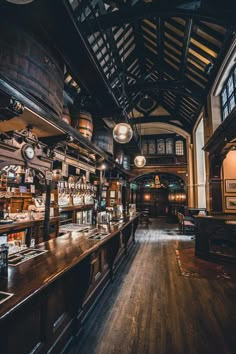 an old fashioned bar with lots of bottles on the shelves and lights hanging from the ceiling