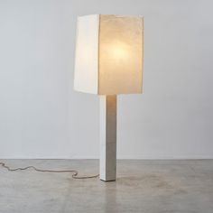 a lamp that is on top of a white surface with a cord attached to it