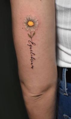 a woman's arm with a daisy on it and the words, i love you in cursive writing