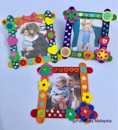 three colorful frames with buttons and flowers on them, one is holding a small child