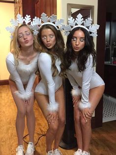 three women in white costumes posing for the camera with their hands on their hipss