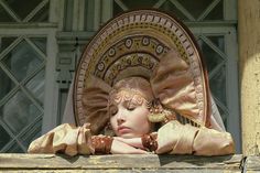 a close up of a statue wearing a hat on top of a window sill