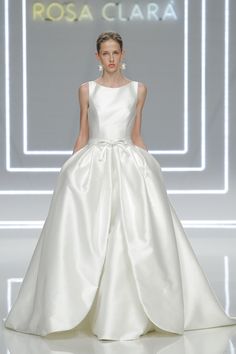 a woman in a white wedding dress on the runway at rosa clara fashion show