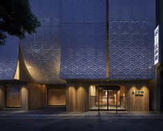 the entrance to an office building lit up at night with lights shining on it's facade