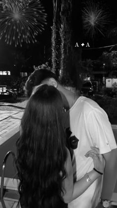 a man and woman kissing in front of fireworks