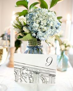 there is a vase with some flowers in it and a place card on the table